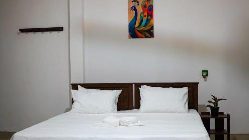 a bed with two white towels on top of it at Mango Oasis - Holiday Bangalow in Habarana