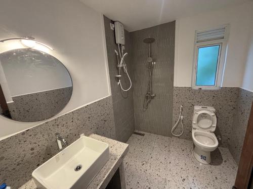 a bathroom with a sink and a toilet and a mirror at Citron Cottage in Kandy