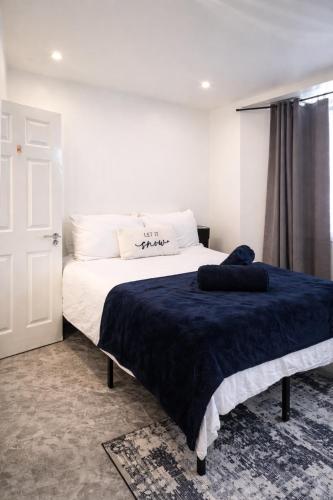 a bedroom with a bed with a blue blanket on it at La Rose Serenity Residence Elegant Rooms in London
