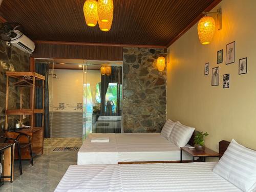 a bedroom with two beds and a walk in shower at Flora Garden Homestay in Xuân Sơn