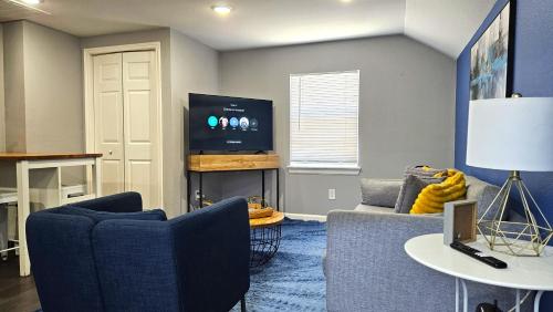 a living room with two blue chairs and a tv at Super Cozy 2 bedroom with Fast WIFI and Queen Bed close to Downtown Houston!! in Houston