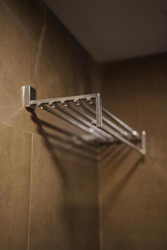 a metal towel rack on the wall of a bathroom at Aostel in Chennai