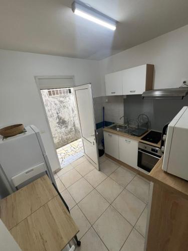 a small kitchen with a refrigerator and a stove at SOLEY City Break 13 in Les Abymes