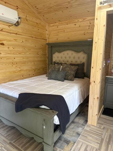 a bedroom with a bed in a wooden cabin at Off the Road Oasis in Lufkin