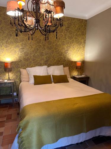 a bedroom with a large bed with a chandelier at Bastide Aïna SPA et piscine in Grasse