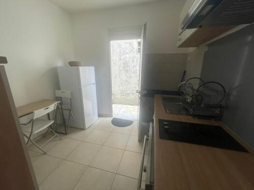 a small kitchen with a sink and a refrigerator at SOLEY City Break 13 in Les Abymes