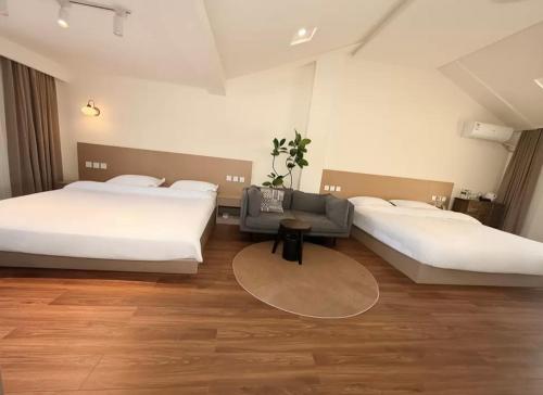 a hotel room with two beds and a table at 宣萱民宿 in Mile