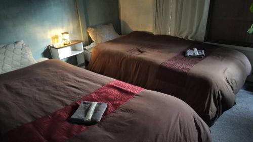 two beds in a hotel room with towels on them at 101個室元芸者の隠れ宿湯河原 in Yugawara
