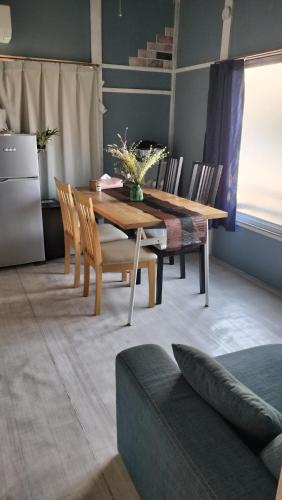 a dining room with a wooden table and chairs at 101個室元芸者の隠れ宿湯河原 in Yugawara