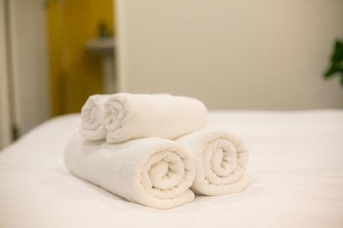 a pile of towels sitting on top of a bed at Siri Space สิริ สเปซ in Ban Khlong Nung (1)