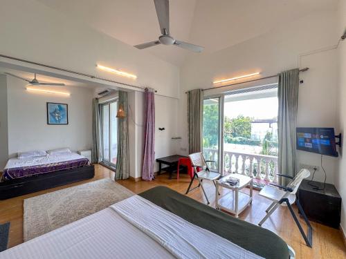 a bedroom with a bed and a balcony at NIVANTA-CREAZE by Bendre's in Kārli