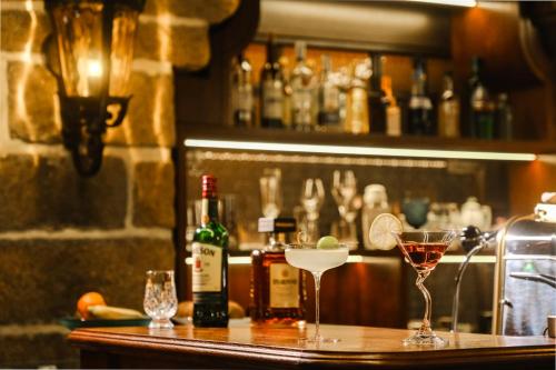 a bar with two glasses and bottles of alcohol at Hui-TEXACO in Gulang Yu