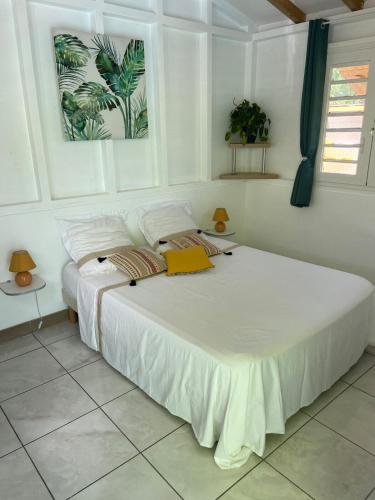 a bedroom with a large white bed in a room at Exceptional bungalow with private pool in Rivière-Pilote