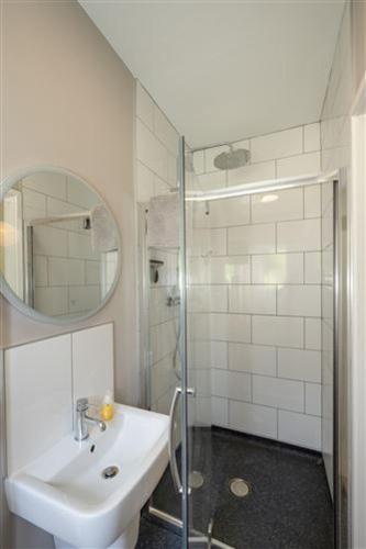 a white bathroom with a sink and a shower at Ocean View in Rosscarbery