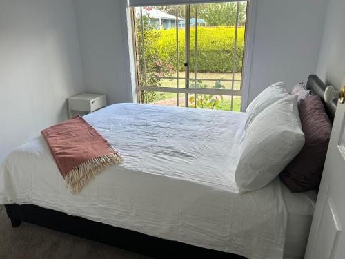 a bed in a room with a large window at Millingtons Beach House in Orford