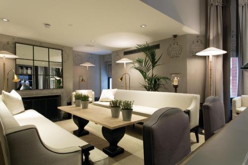 a living room filled with furniture and a table at The Franklin London - Starhotels Collezione in London