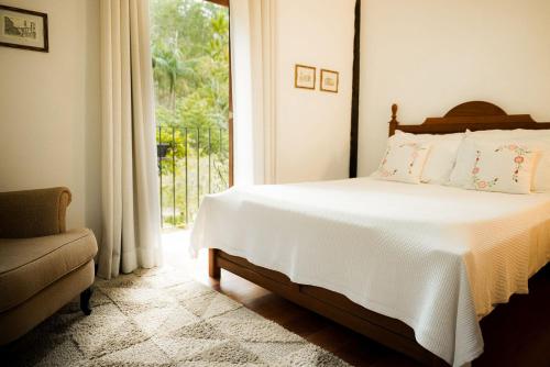 a bedroom with a bed and a large window at Pousada do Nonno in Venda Nova do Imigrante