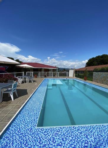 a large swimming pool with a blue at Hotel La Casona Quindío Eje Cafetero in Montenegro