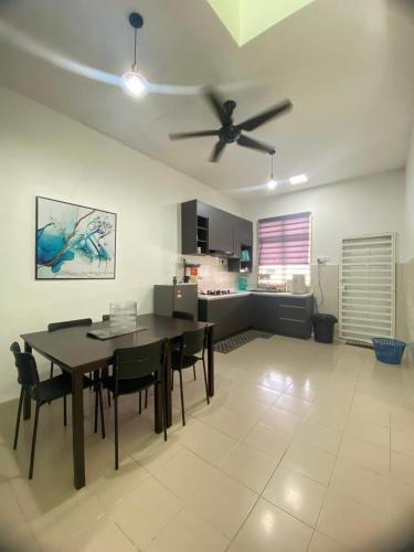 a living room with a dining table and a ceiling fan at Impian May Homestay 1,Taman Koperat Putera in Kampung Raja
