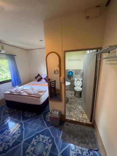 a bedroom with a shower and a bed and a toilet at Baan Klong House in Baan Khai