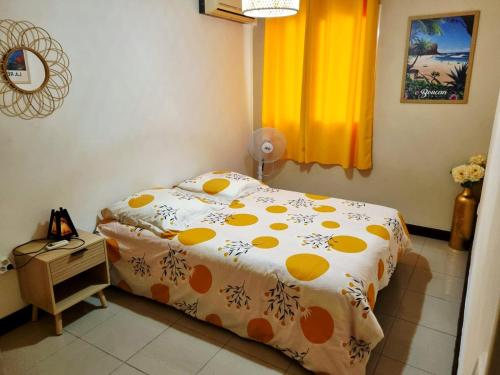 a bedroom with a bed with an orange and white comforter at KDS appartement T2 Île de la Réunion in Saint-Denis