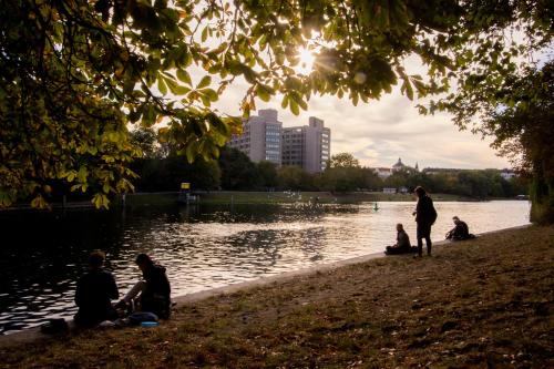 a group of people sitting on the shore of a lake at Grimm's Berlin Mitte in Berlin