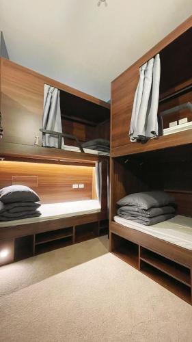 a room with two bunk beds with wooden shelves at Georgie Accommodation in Auckland