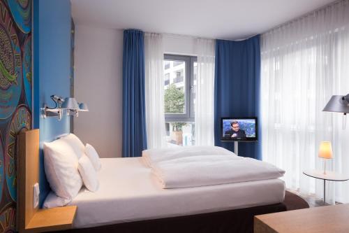 a bedroom with a large white bed with blue walls at Grimm's Berlin Mitte in Berlin