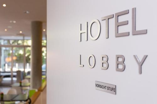 a sign for a hotel lobby with a hotel logo at Grimm's Berlin Mitte in Berlin