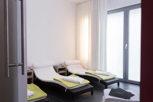 a hospital room with three chairs and a window at Grimm's Berlin Mitte in Berlin