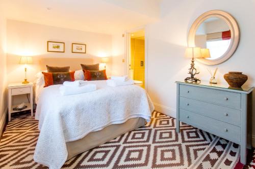 a bedroom with a bed with a blue dresser and a mirror at The Lily Pad in Thorpeness