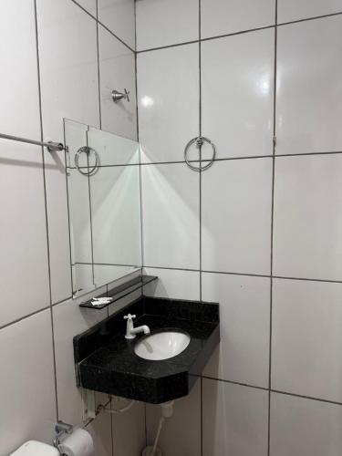 a bathroom with a sink and a mirror at Hotel 44 Oliveira in Goiânia