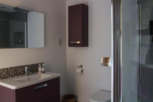 a bathroom with a sink and a toilet and a mirror at Holywell Bay B & B in Newquay