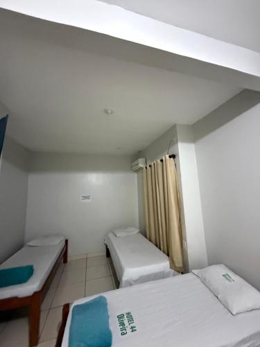 a small room with two beds and a window at Hotel 44 Oliveira in Goiânia