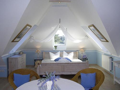 ein Schlafzimmer mit einem Bett mit zwei Tischen und einem Fenster in der Unterkunft Haus Anholt in Timmendorfer Strand