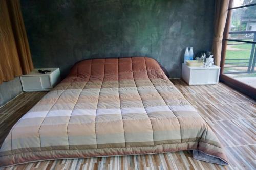 a bed in a bedroom with a large bedspread at Phu Pha View Doi in Samoeng