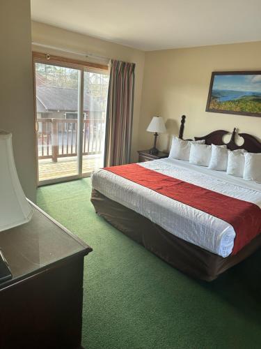 a hotel room with a large bed and a window at Studio 6 Lake George NY Adirondacks in Lake George