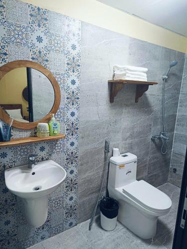 a bathroom with a toilet and a sink and a mirror at a Hue Homestay in Hue