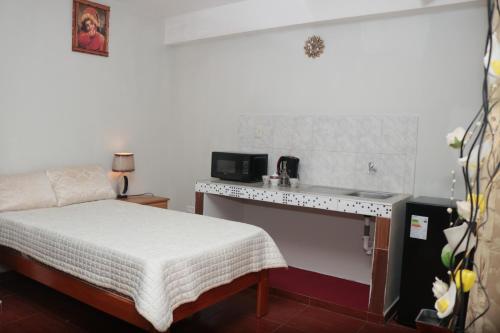 a small bedroom with a bed and a desk at Lechugal Guest House in Cusco