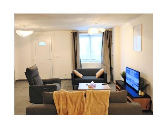 a living room with two couches and a tv at Ô Bon Goût in Bourges