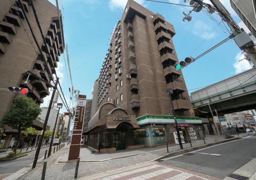 a tall building on the corner of a city street at Shinsaibashi ARTY Inn in Osaka