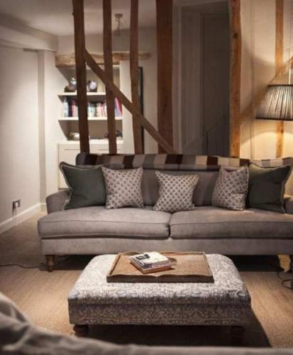 a living room with a couch and a table at Jasmine Cottage, Upper Slaughter, Cotswolds in Cheltenham