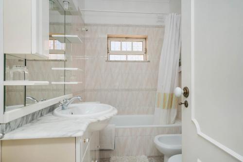 a white bathroom with a sink and a toilet at Villa Cerrinho by Gabi Miguel in Albufeira