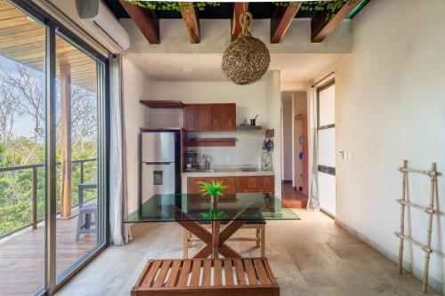 a kitchen with a glass table and a refrigerator at Master Jungle Penthouse with Large Private Terrace - Santuario Hotel Boutique in Chemuyil