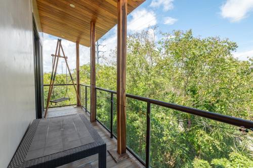 a room with a balcony with a view of trees at Master Jungle Penthouse with Large Private Terrace - Santuario Hotel Boutique in Chemuyil