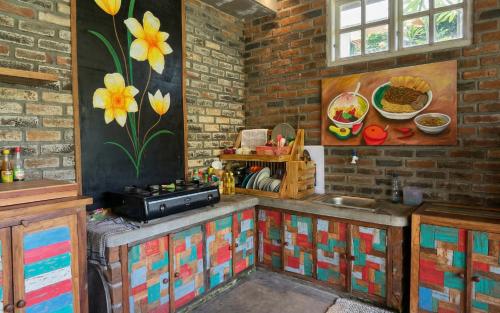 a kitchen with a painting on the wall at Sirya Farm House in Meliling