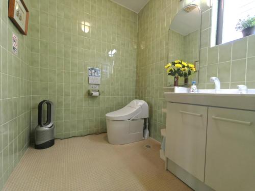 a bathroom with a toilet and a sink and a mirror at Via Tsuru鶴苑1 minute from the station! in Izumi-Sano