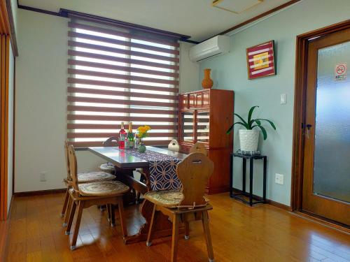 a dining room with a table and chairs and a window at Via Tsuru鶴苑1 minute from the station! in Izumi-Sano