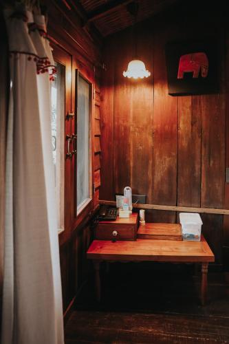 a wooden room with a table and a window at Baan Mon Muan in Mon Jam