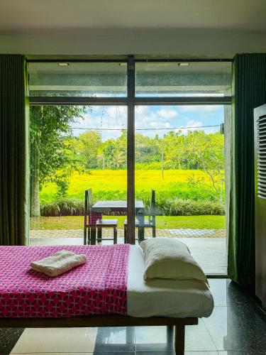 a bedroom with a bed and a view of a garden at Leisure Land in Galle